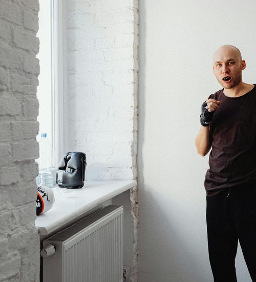 Fit man standing confidently after a workout session, looking energetic.